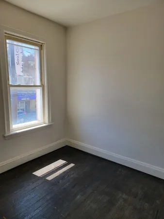 a view of a small space with wooden floor and a window