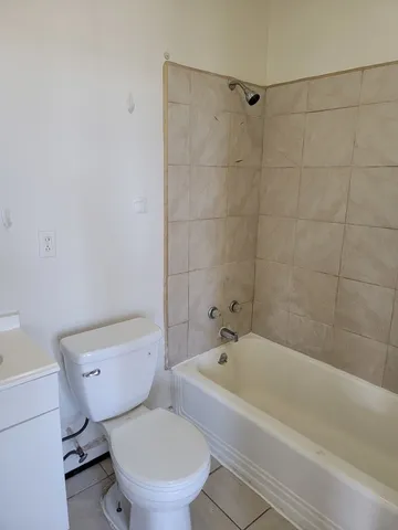 a white toilet and tub sitting next to a bathroom sink