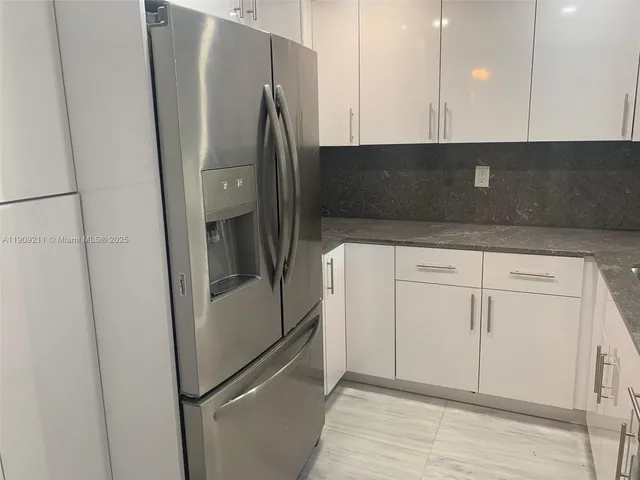 a kitchen with stainless steel appliances a refrigerator and cabinets