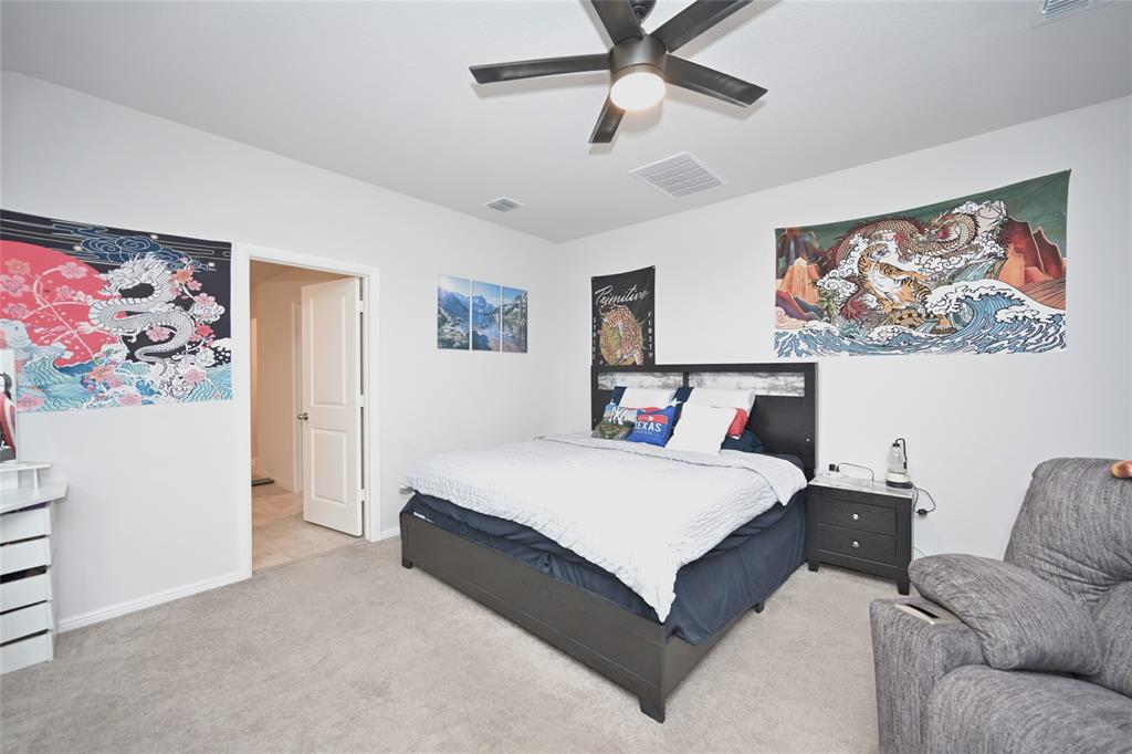 3713 Ridgeway Lane Argyle, TX 76226 - Photo 17 of 40 a spacious bedroom with a bed and a painting on the wall