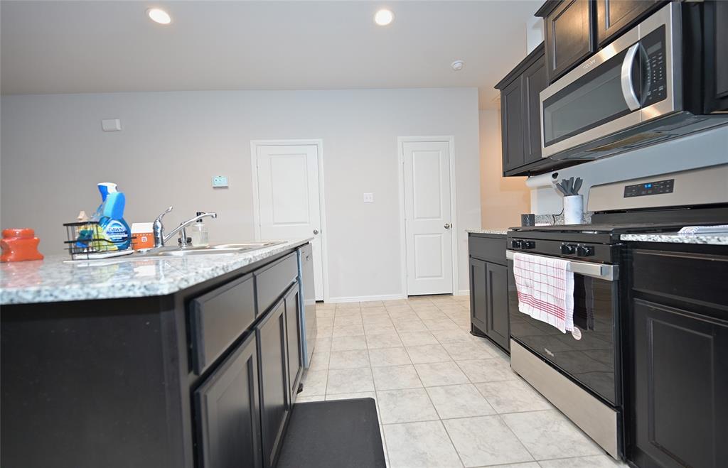 3713 Ridgeway Lane Argyle, TX 76226 - Photo 5 of 40 a kitchen with stainless steel appliances granite countertop a sink and a stove