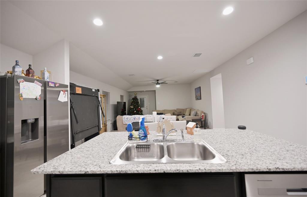 3713 Ridgeway Lane Argyle, TX 76226 - Photo 7 of 40 a kitchen with kitchen island granite countertop a sink and refrigerator