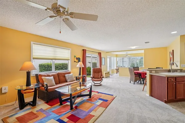 a living room with furniture a flat screen tv and a large window