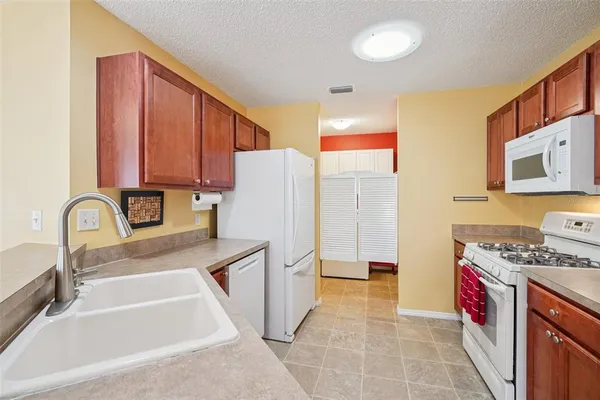 a kitchen with stainless steel appliances granite countertop a refrigerator a stove top oven a sink and dishwasher