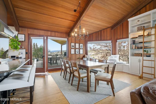 a dining room with furniture and a floor to ceiling window