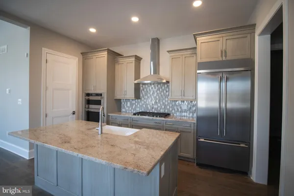a kitchen with kitchen island a counter top space cabinets and stainless steel appliances
