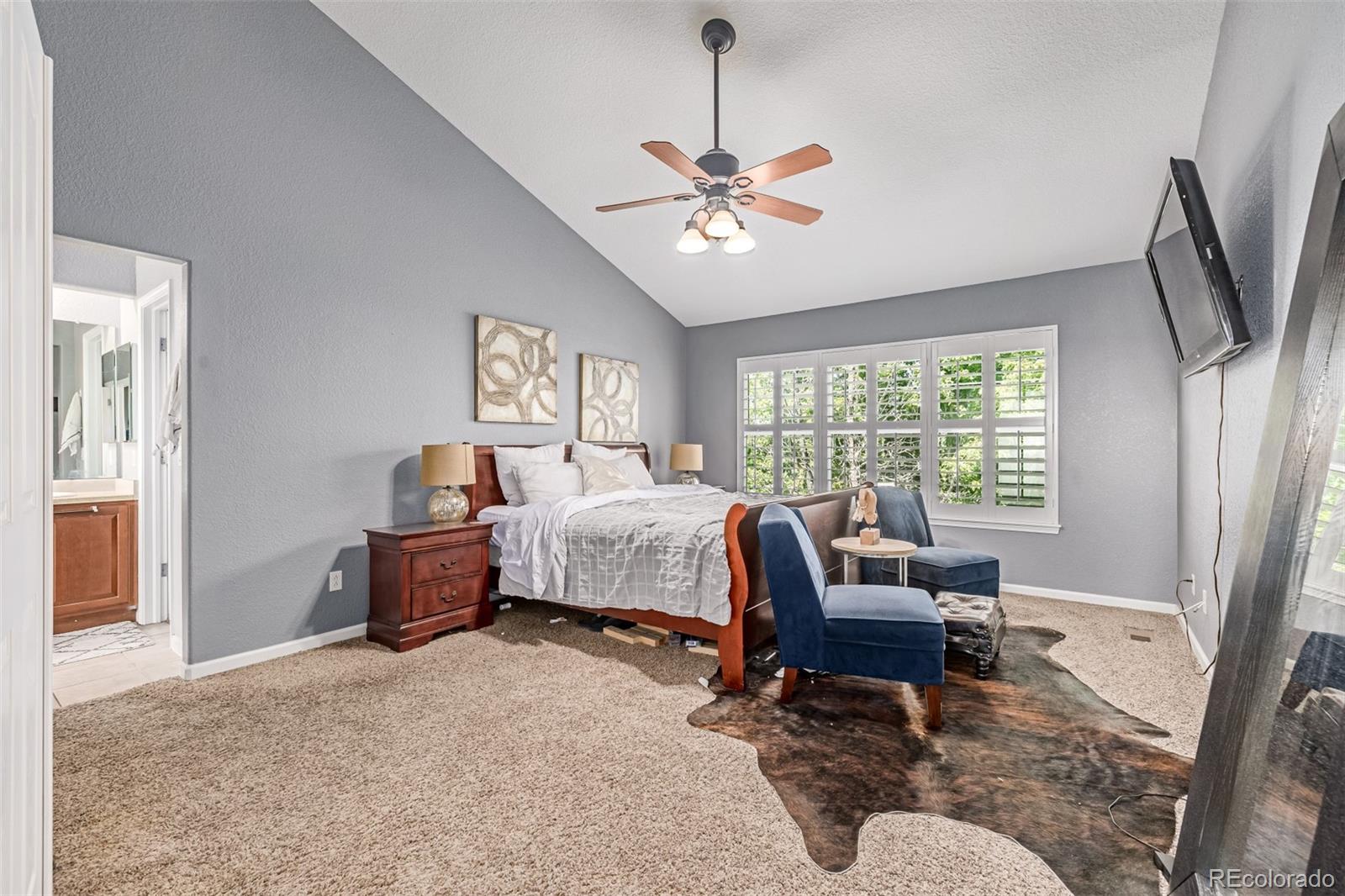 24248 East Roxbury Circle Aurora, CO 80016 - Photo 13 of 42 a bedroom with a bed and a chandelier