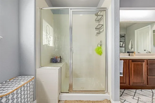a bathroom with a shower a mirror and a sink