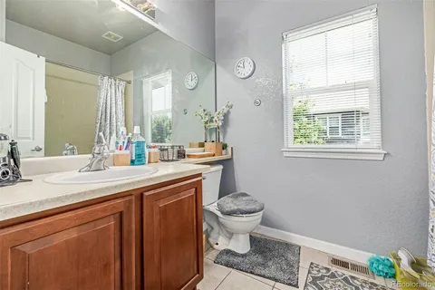 a bathroom with a sink toilet a mirror and a window