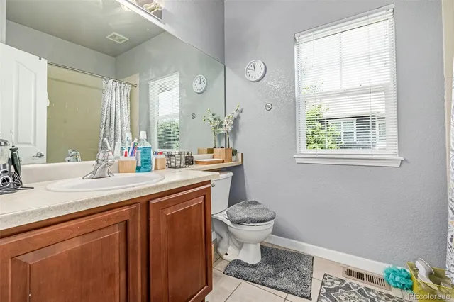 a bathroom with a sink toilet a mirror and a window