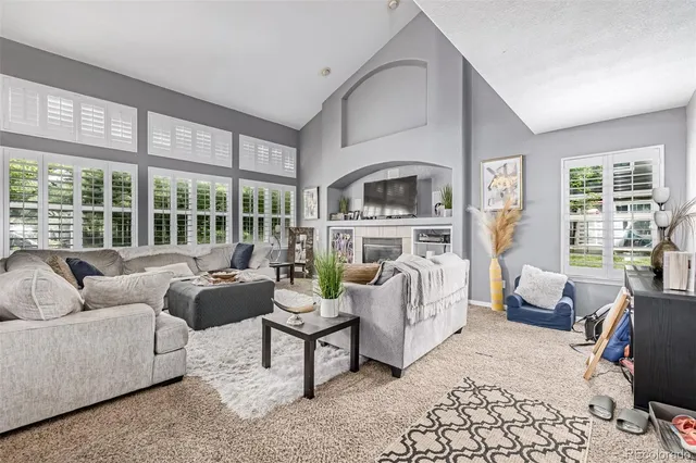 a living room with furniture fireplace and a large window