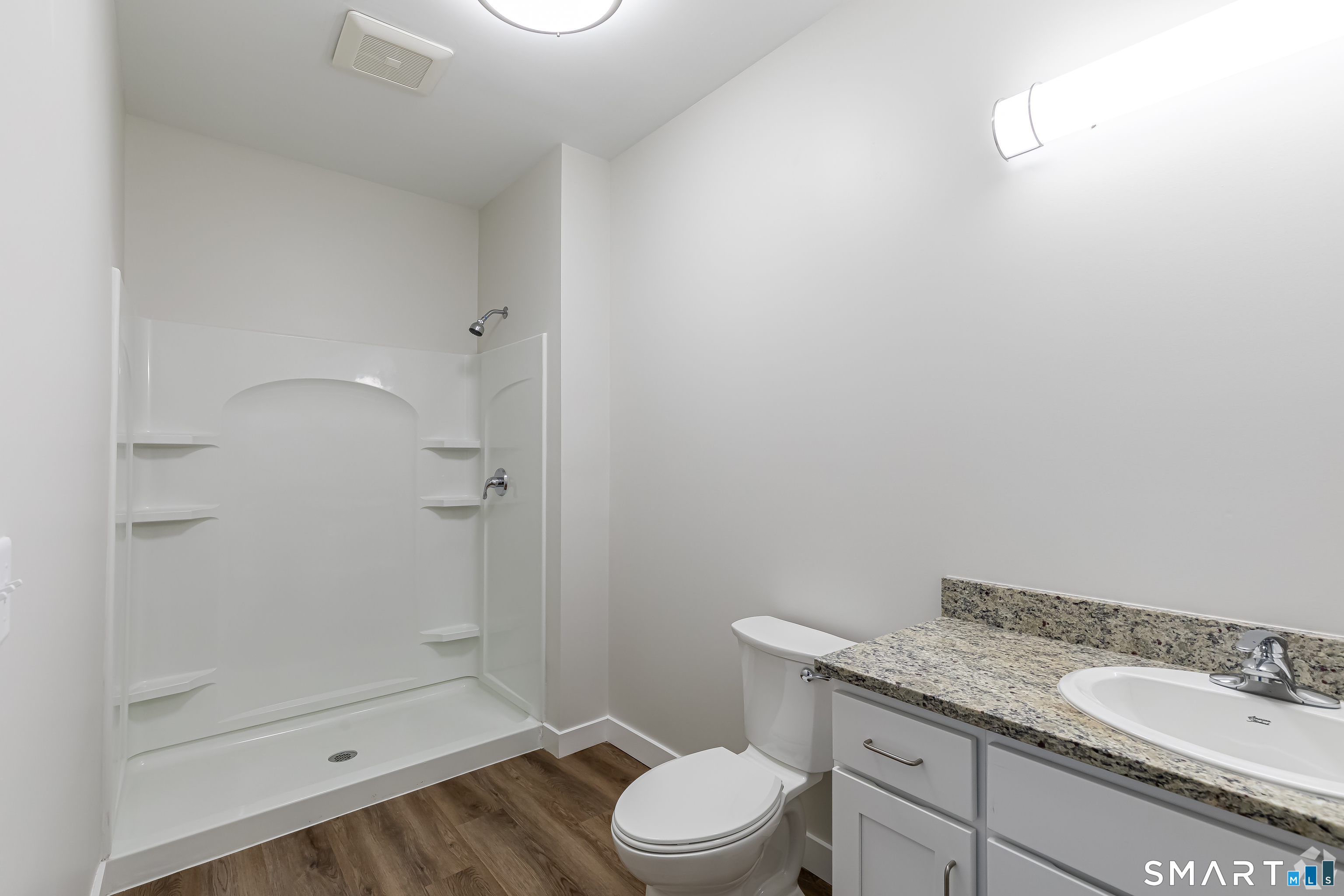 401 Albany Turnpike, Unit 311 Canton, CT 06019 - Photo 7 of 11 a bathroom with a granite countertop sink toilet and shower