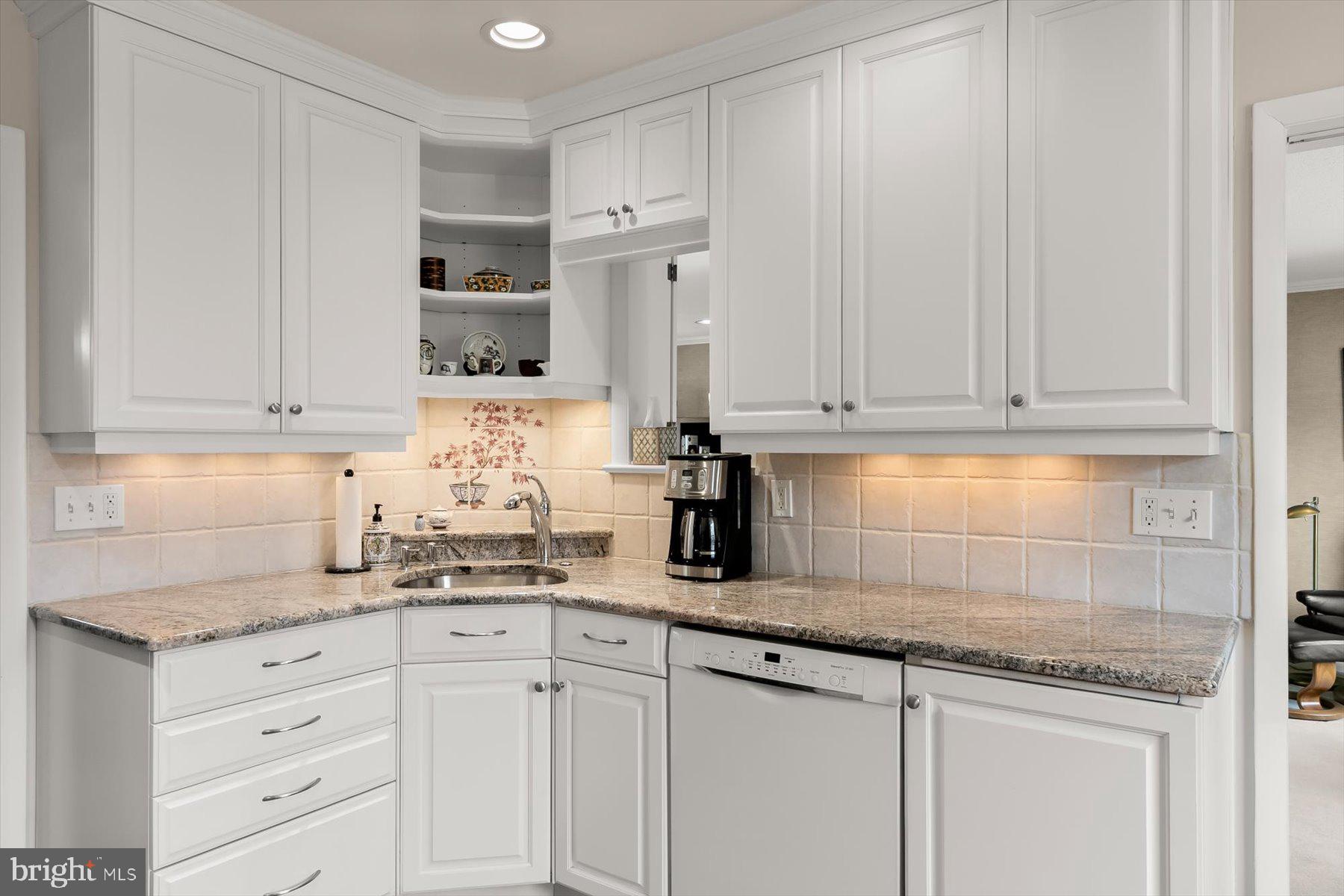 4716 Merivale Road Chevy Chase, MD 20815 - Photo 16 of 48 a kitchen with granite countertop white cabinets and white appliances