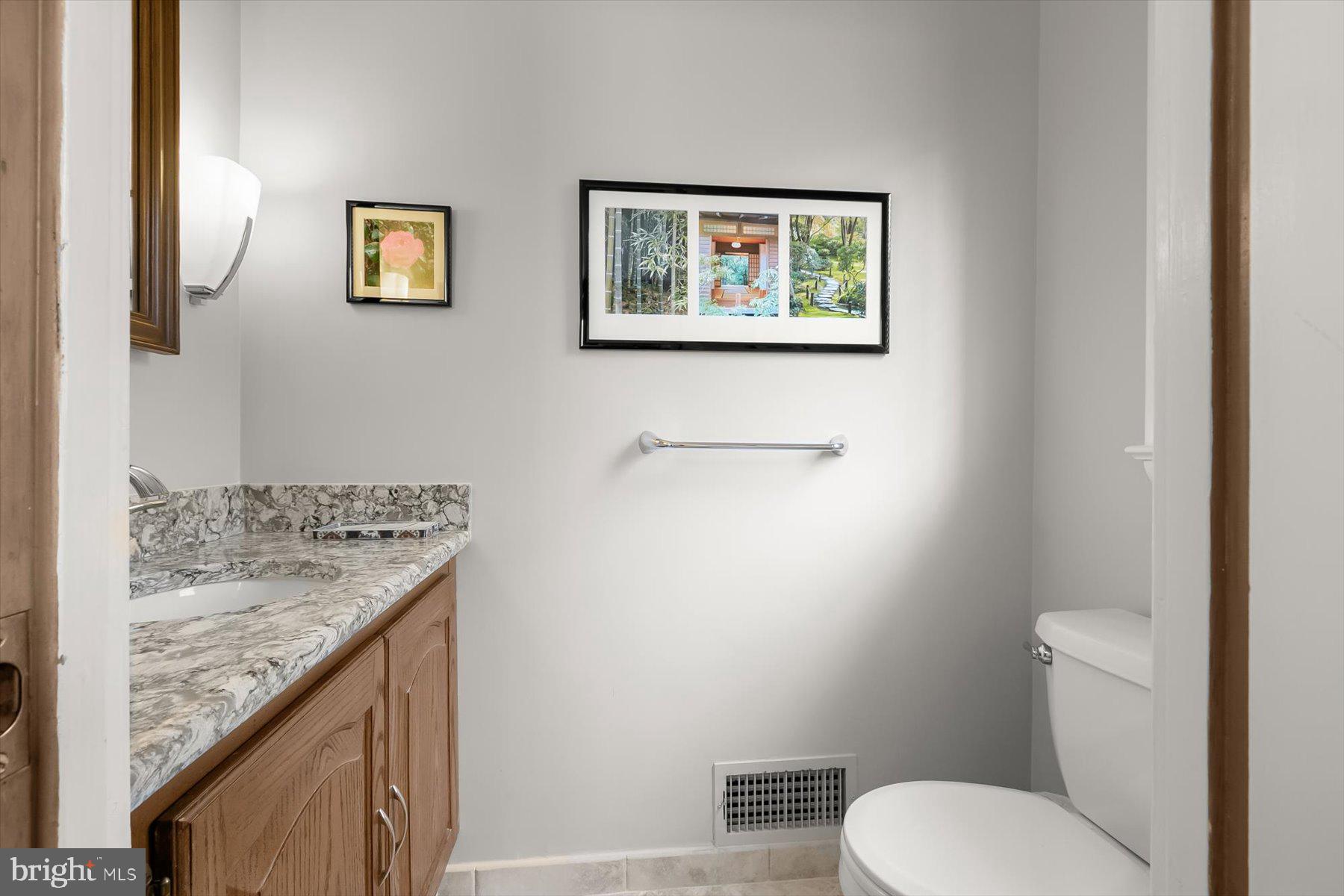 4716 Merivale Road Chevy Chase, MD 20815 - Photo 20 of 48 a bathroom with a granite countertop toilet and a sink