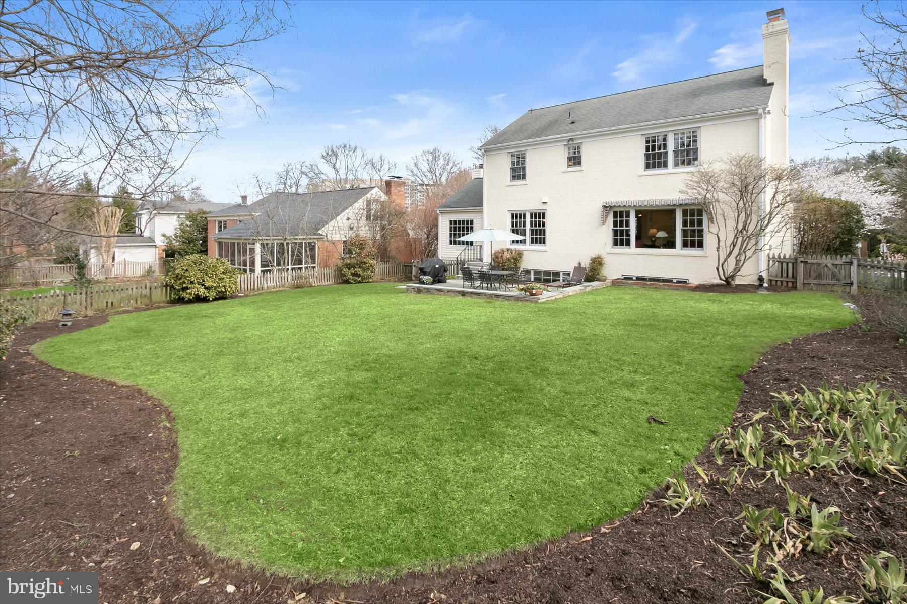 4716 Merivale Road Chevy Chase, MD 20815 - Photo 3 of 48 a view of a white house in front of a big yard with large trees