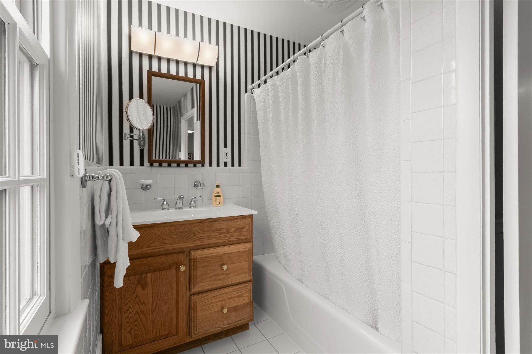 4716 Merivale Road Chevy Chase, MD 20815 - Photo 31 of 48 a bathroom with a sink a mirror and a bathtub