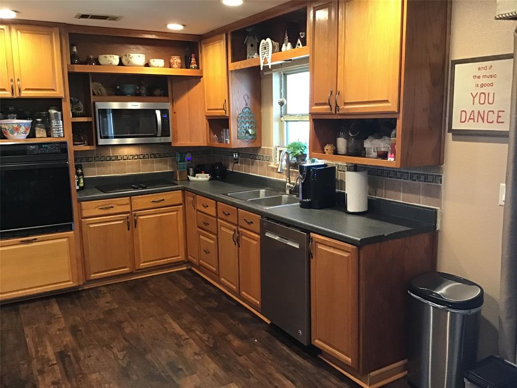 a kitchen with granite countertop stainless steel appliances a stove sink and microwave