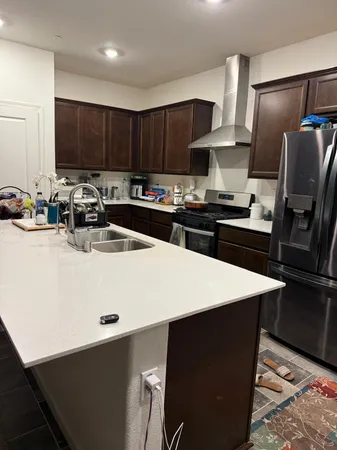 a kitchen with stainless steel appliances a stove refrigerator sink and cabinets