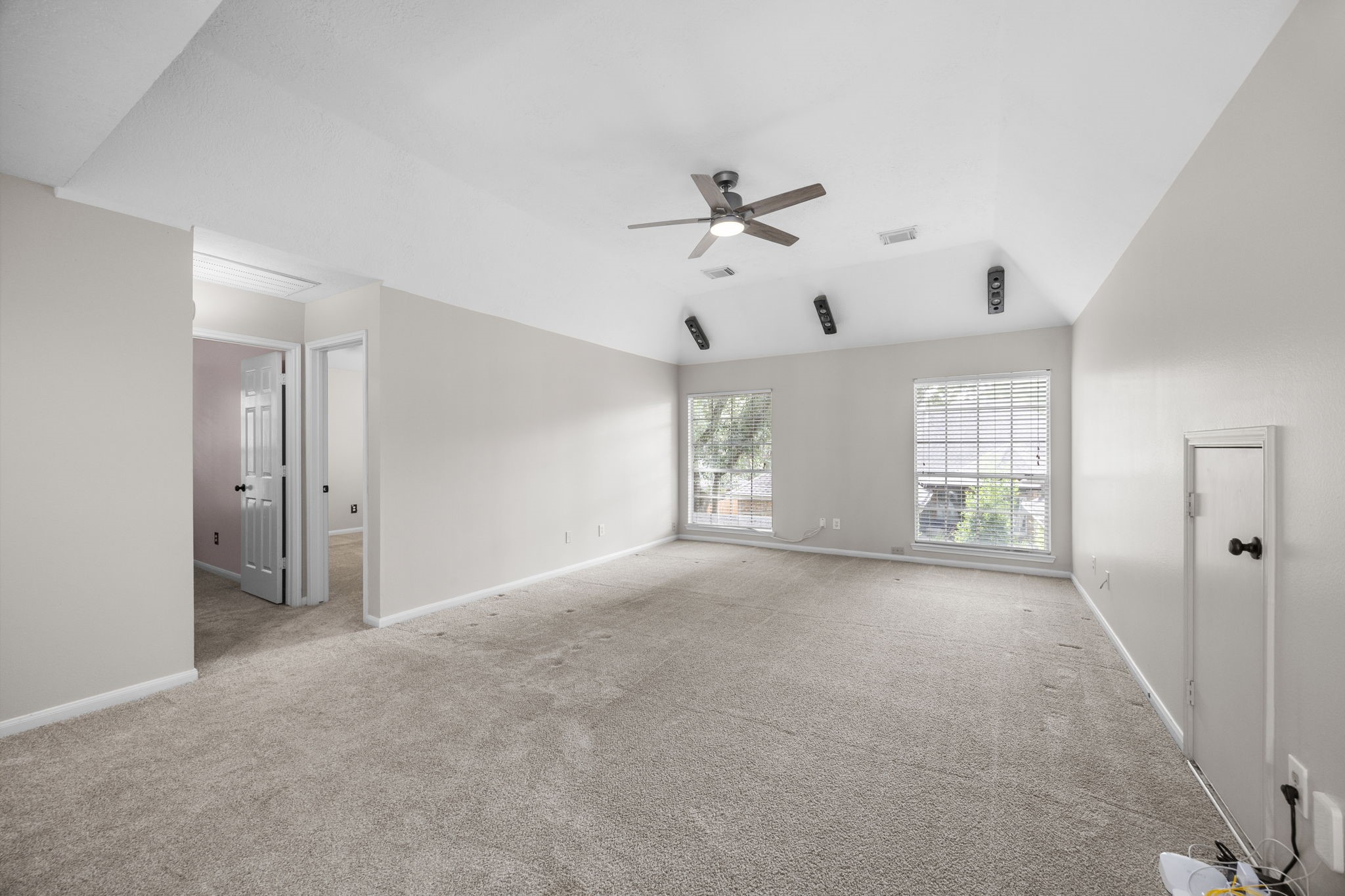 9015 Rhapsody Lane Houston, TX 77040 - Photo 27 of 39 At the top of the stairs, you’re welcomed into a large game room with plenty of space for lounging, gaming, and entertaining. The vaulted ceiling and large windows make the room feel bright and open, creating a great second living area upstairs.