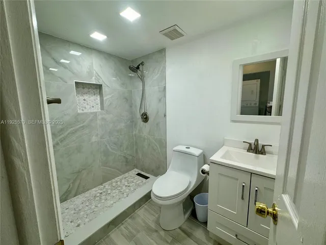 a bathroom with a sink a toilet and shower