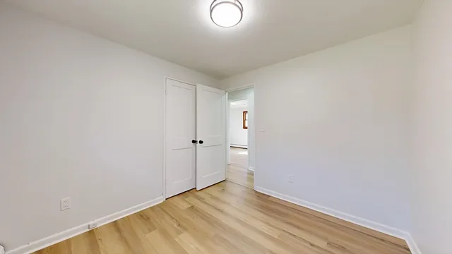 a view of a room with wooden floor and white walls