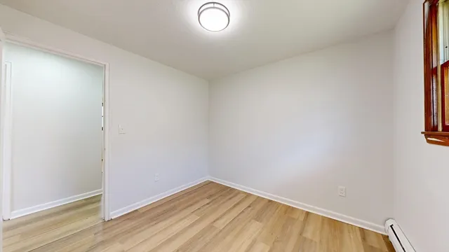 a view of a room with wooden floor and a window