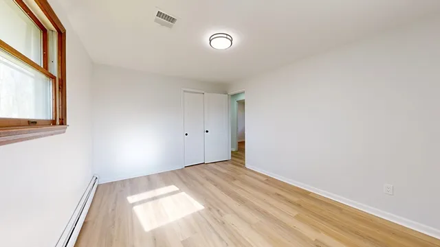 a view of empty room with wooden floor