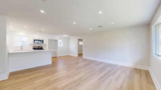 a view of kitchen with kitchen island granite countertop stainless steel appliances refrigerator and microwave