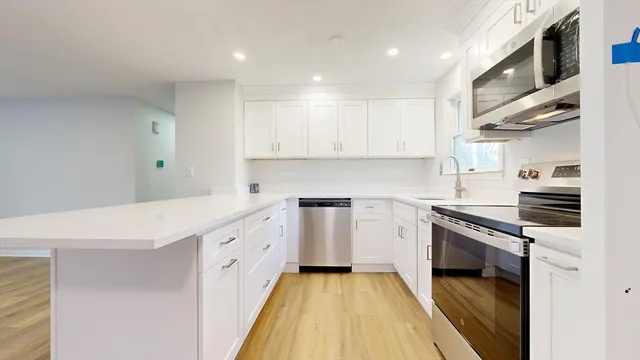 a kitchen with granite countertop white cabinets and white appliances