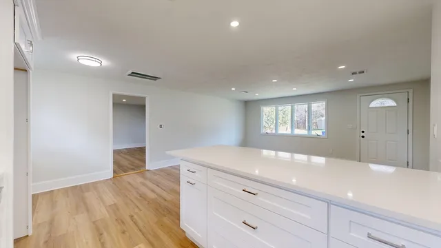a kitchen with a wooden floor and natural light