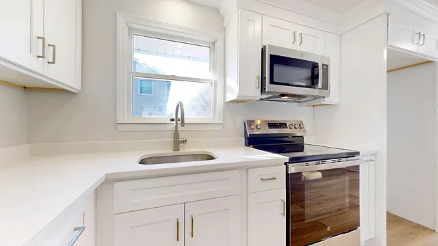 a kitchen with stainless steel appliances granite countertop a sink and a microwave