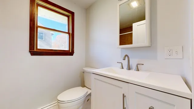 a bathroom with a toilet sink vanity and mirror