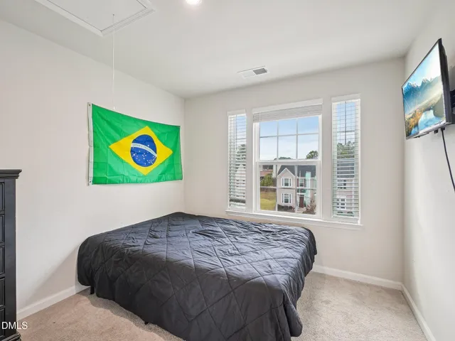 a bedroom with a bed and a painting on the wall