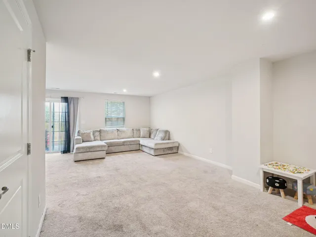 a view of a livingroom with wooden floor and bathroom