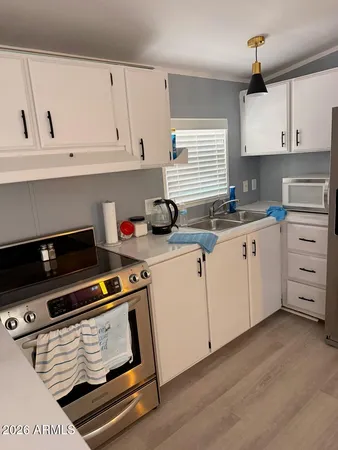 a kitchen with appliances a sink and cabinets