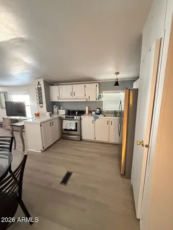 a view of a kitchen with refrigerator and white cabinets