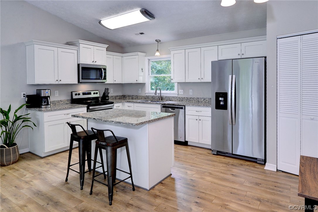 250 Reflection Drive Williamsburg, VA 23188 - Photo 13 of 42 a kitchen with stainless steel appliances granite countertop a table chairs microwave and sink