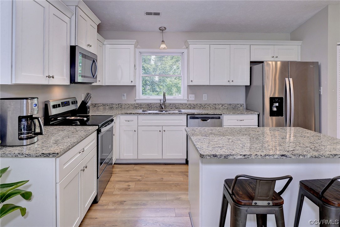 250 Reflection Drive Williamsburg, VA 23188 - Photo 14 of 42 a kitchen with stainless steel appliances granite countertop a white cabinets granite counter tops and a stove