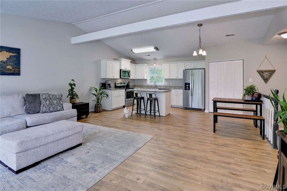 250 Reflection Drive Williamsburg, VA 23188 - Photo 9 of 42 a living room with furniture and a dining table with kitchen view