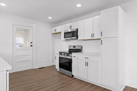 a kitchen with stainless steel appliances granite countertop a stove a sink and a refrigerator