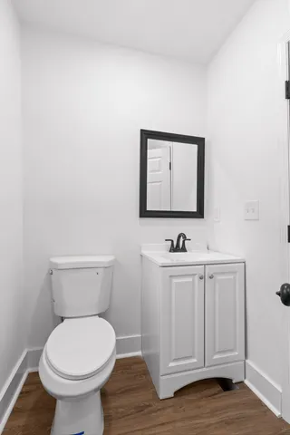 a bathroom with a toilet a sink and mirror