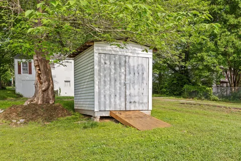 a backyard of a house with plants and large trees