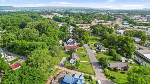an aerial view of residential houses with outdoor space and trees