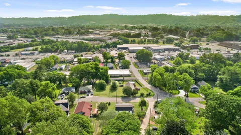 an aerial view of residential houses with outdoor space and trees