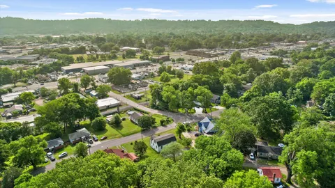 an aerial view of residential houses with outdoor space and trees