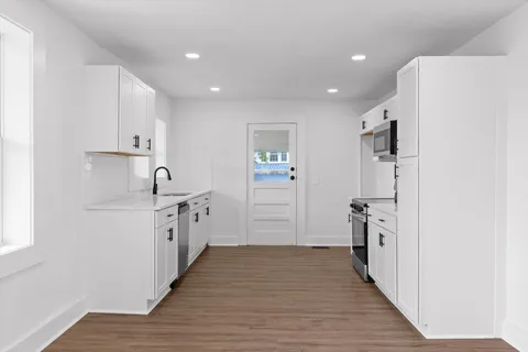 a large kitchen with a refrigerator and a sink
