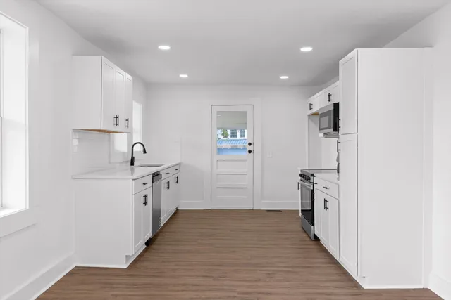 a large kitchen with a refrigerator and a sink