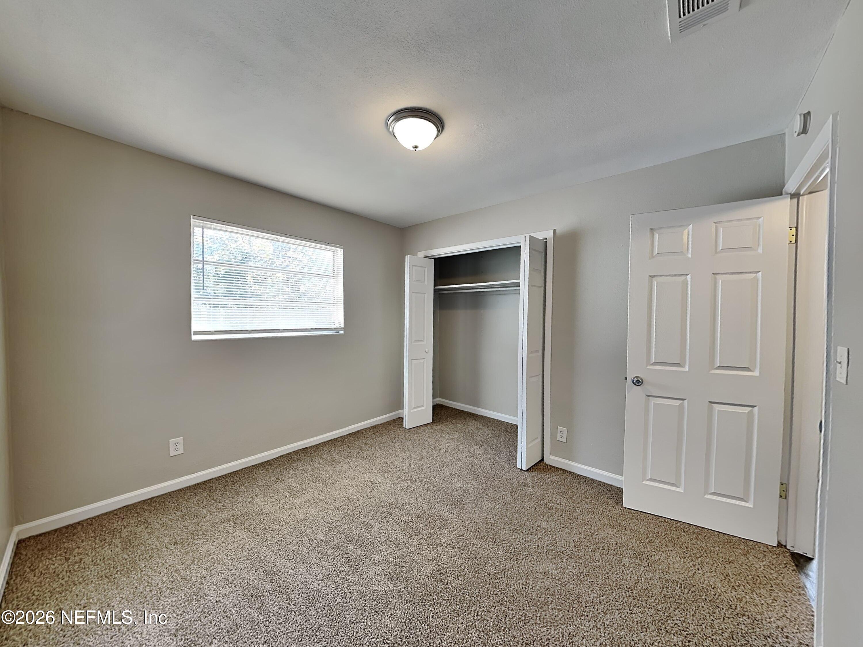 3403 Rogero Road Jacksonville, FL 32277 - Photo 13 of 19 an empty room with windows and closet