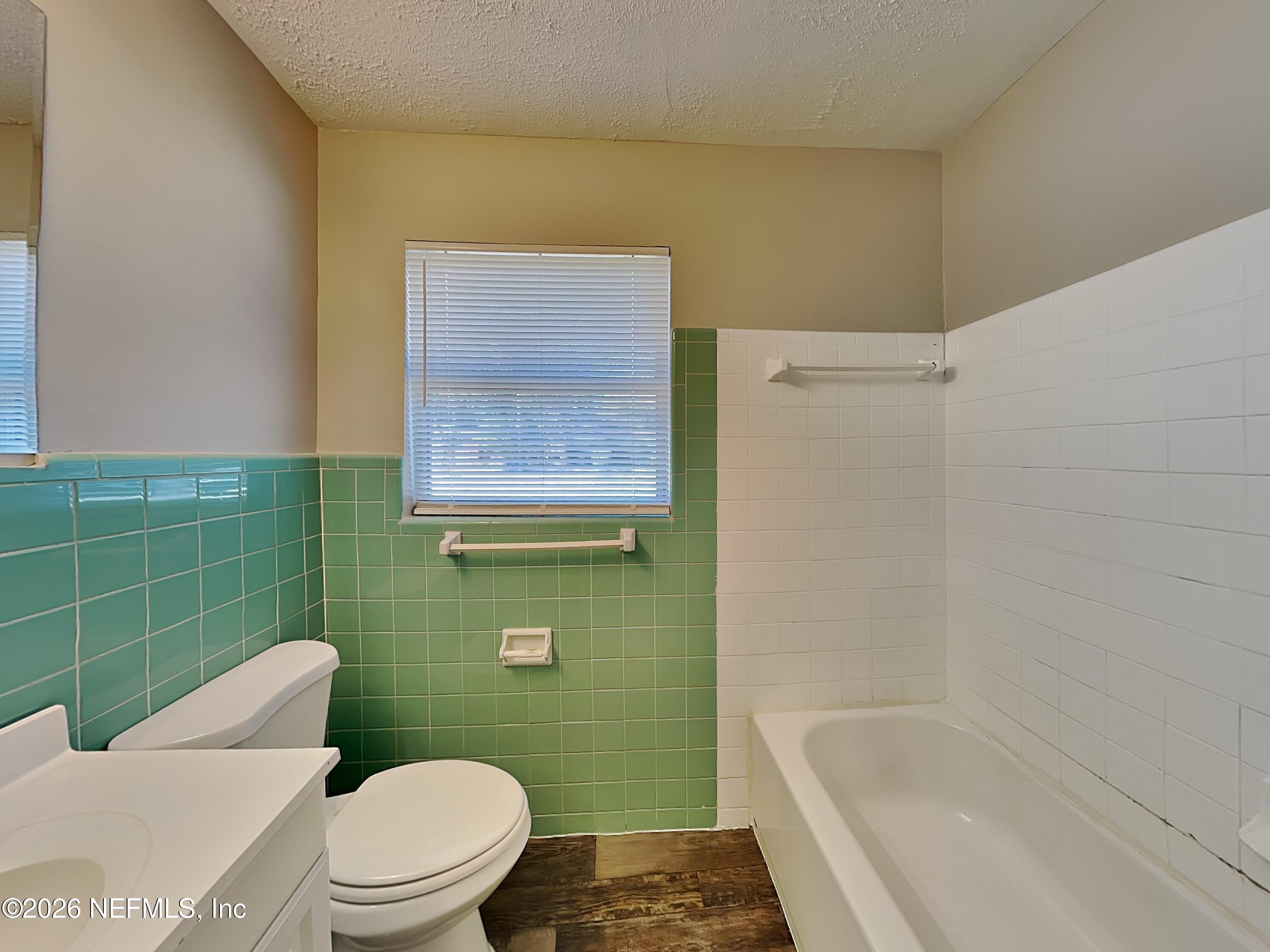 3403 Rogero Road Jacksonville, FL 32277 - Photo 16 of 19 a white toilet sitting next to a bathroom sink and tub