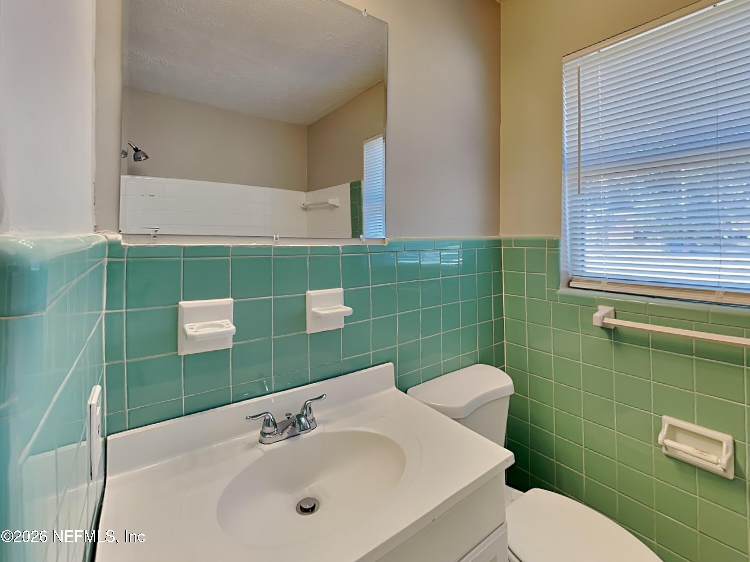 3403 Rogero Road Jacksonville, FL 32277 - Photo 17 of 19 a bathroom with a sink mirror and toilet